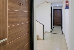 A hallway with a wooden door marked "402" and a tiled floor. - Townhouse Mumbai International Airport (Mumbai)