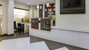 A reception area with a reception desk, a computer, and a clock on the wall.