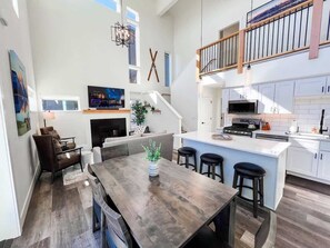 A spacious open-plan living area with a dining table, kitchen, and seating area.