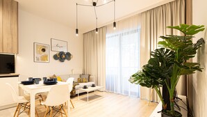 A modern living room with a dining area, a large plant, and a sofa. - Campo Twoja Oaza w Shellter Rogowo (Trzebiatow)