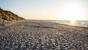 A beach with a sandy shore, a wooden fence, and the ocean in the background. - Campo Twoja Oaza w Shellter Rogowo (Trzebiatow)