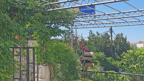 A gated entrance with a stone wall, potted plants, and a sign for 'Orange' apartments. - Holiday Home Gordana - Charming Deluxe Apartment in fabulous Hvar (HVAR (HVAR))
