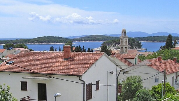 A coastal town with buildings and a prominent tower. - Holiday Home Gordana - Charming Deluxe Apartment in fabulous Hvar (HVAR (HVAR))