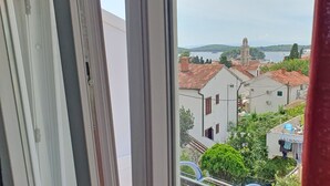 A view from a window with a view of a town, including buildings and a body of water. - Holiday Home Gordana - Charming Deluxe Apartment in fabulous Hvar (HVAR (HVAR))