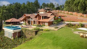 Una casa grande y moderna con piscina, varias habitaciones y un jardín bien cuidado.