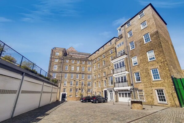 A multi-story brick building with a sign reading "Ford's Greenwich Flour Mills 1897".
