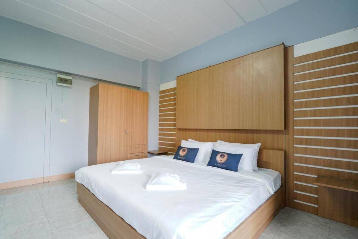 A bedroom with a large bed, wooden headboard, and a wardrobe.