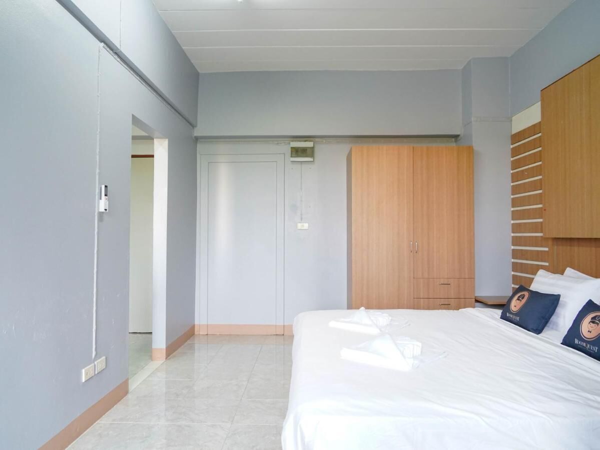 Una habitación de hotel con una cama, un armario y una puerta que da a otra estancia.