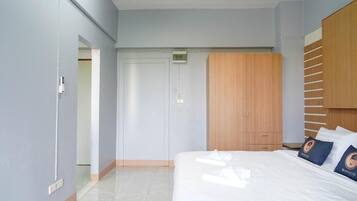 Una habitación de hotel con una cama, un armario y una puerta que da a otra estancia.