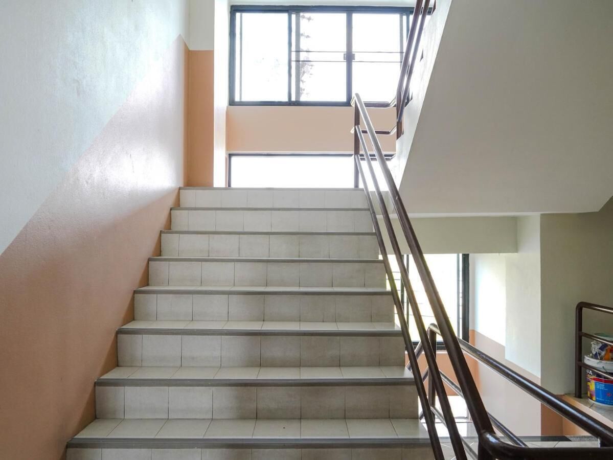 A staircase with a metal handrail leading to a landing.