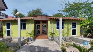 A small, single-story building with a green facade and a brown roof. It has a front entrance with a wooden door and a small porch area. - B&F Travellers Inn (Daanbantayan)
