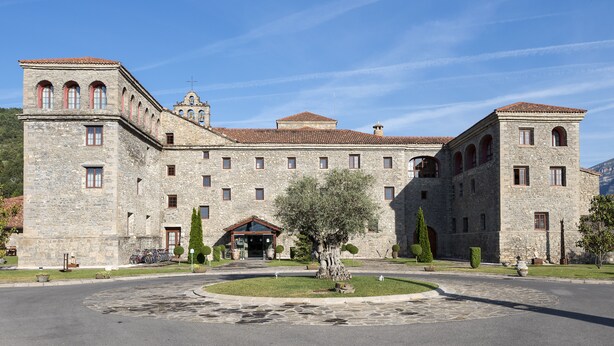 A historic stone building with a central courtyard, arched windows, and a bell tower. - Hotel Monasterio de Boltana & SPA (Boltana)