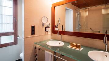 Une salle de bain avec un lavabo en verre, un miroir et des toilettes.