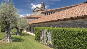 A historic building with a tiled roof, stone walls, and a bell tower.