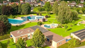 Zona residencial con piscina, fuente y edificio de techo plano.