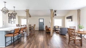 A spacious kitchen with a central island, wooden flooring, and modern bar stools. - Luxury Cottage,  Sleeps 12 , Great Location: minutes to sports complex (Ruston)