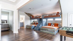 A spacious room with a bunk bed, a desk with a foosball table, and a staircase. - Luxury Cottage,  Sleeps 12 , Great Location: minutes to sports complex (Ruston)