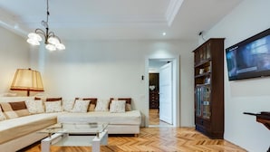 Un salon moderne avec un canapé, une table basse et un téléviseur fixé au mur.