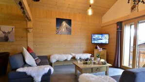 A cozy wooden interior with a sofa, a coffee table with glasses, and a television. - Apartment for 8 people in the center of Châtel - Chatel Reservation (Châtel)