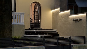 A building entrance with a black metal gate, a marble staircase, and a sign that reads "Alohanian Gem." - Athenian Gem (Athens)