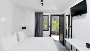 A modern bedroom with a large bed, a flat-screen TV mounted on the wall, and a sliding glass door leading to an outdoor area. - Athenian Gem (Athens)