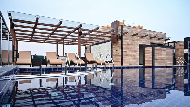 A rooftop pool area with lounge chairs and a pergola. - AGM GRAND HOTEL & SPA (Kanthi)