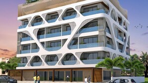 A modern multi-story building with balconies, a curved roof, and a landscaped area with palm trees. - AGM GRAND HOTEL & SPA (Kanthi)