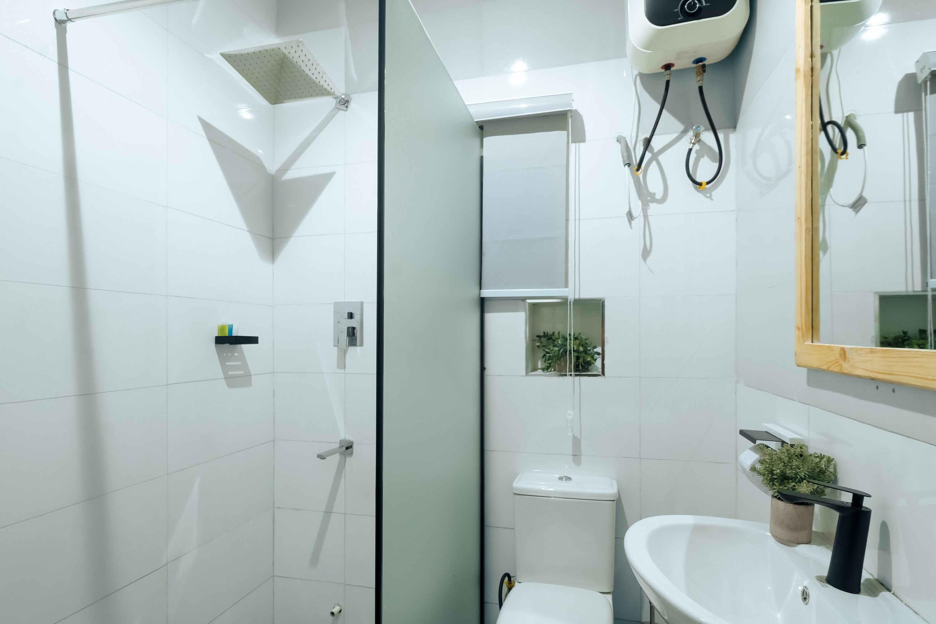 A modern bathroom with a glass shower enclosure, a white sink, and a mirror.