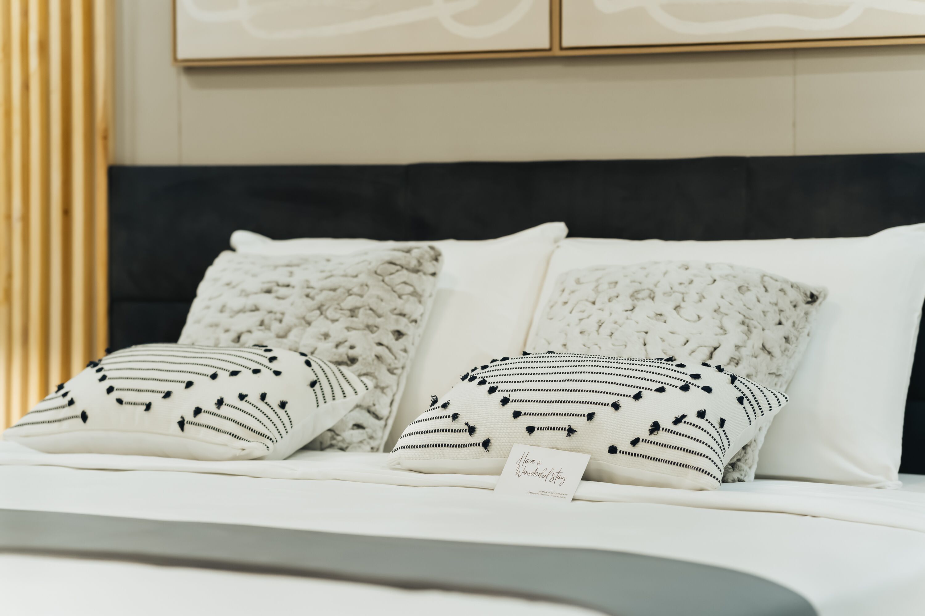 A bed with two pillows, one with a black and white pattern and another with a floral design.
