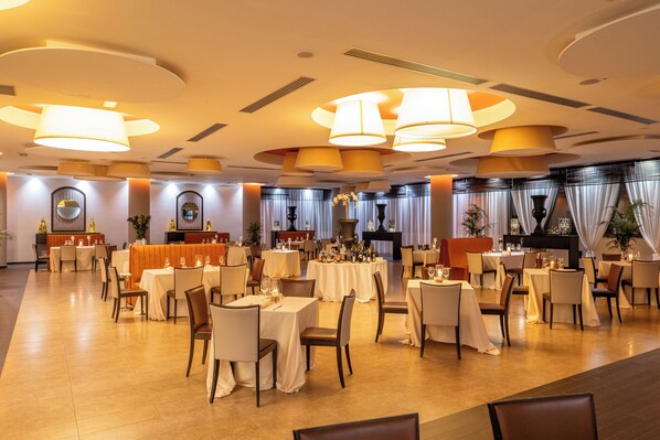 A spacious dining area with multiple round tables, chairs, and ambient lighting fixtures. - Best Western Hotel Palace Lucera (Lucera)