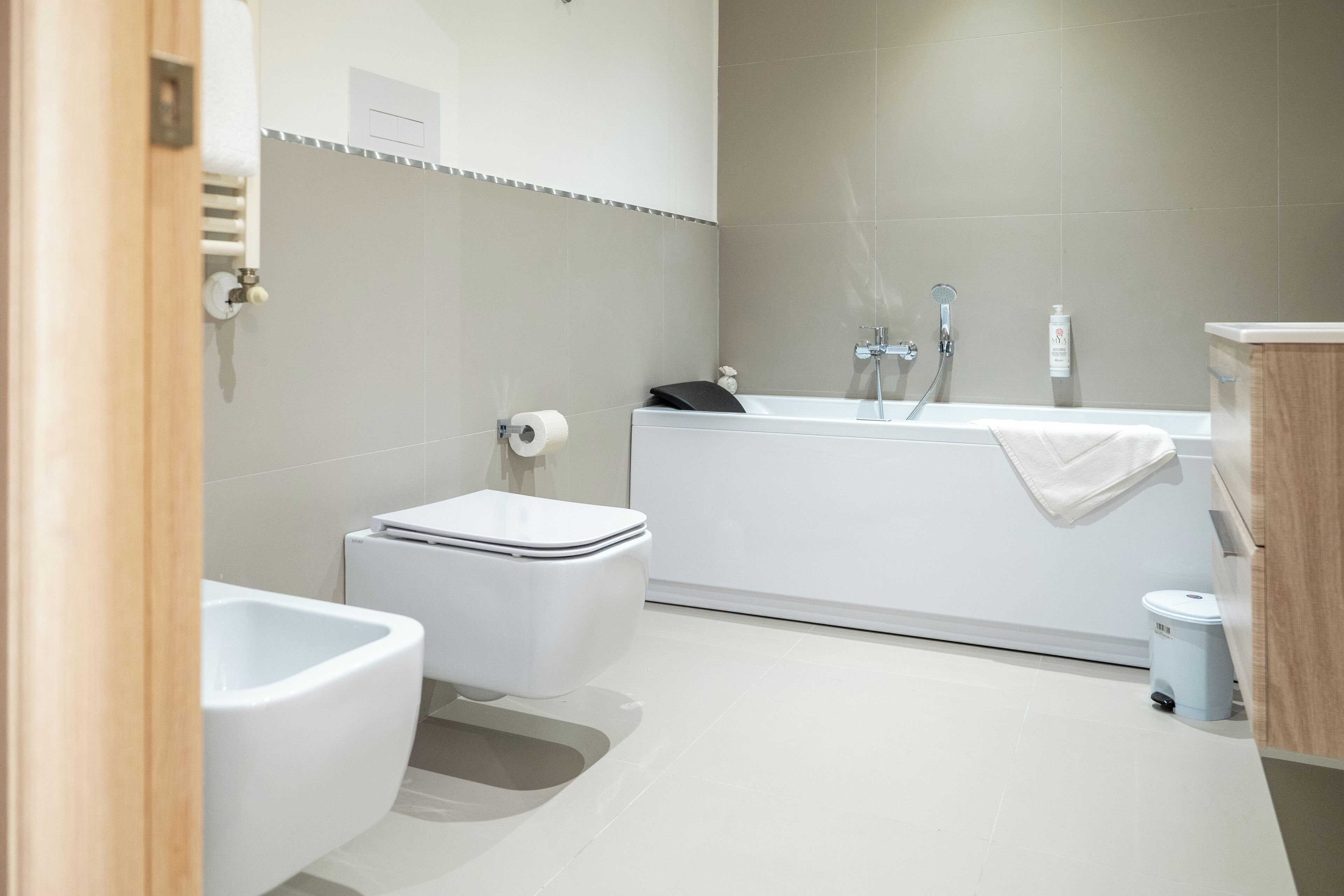 Une salle de bain moderne équipée de toilettes, d’un bidet et d’une baignoire.