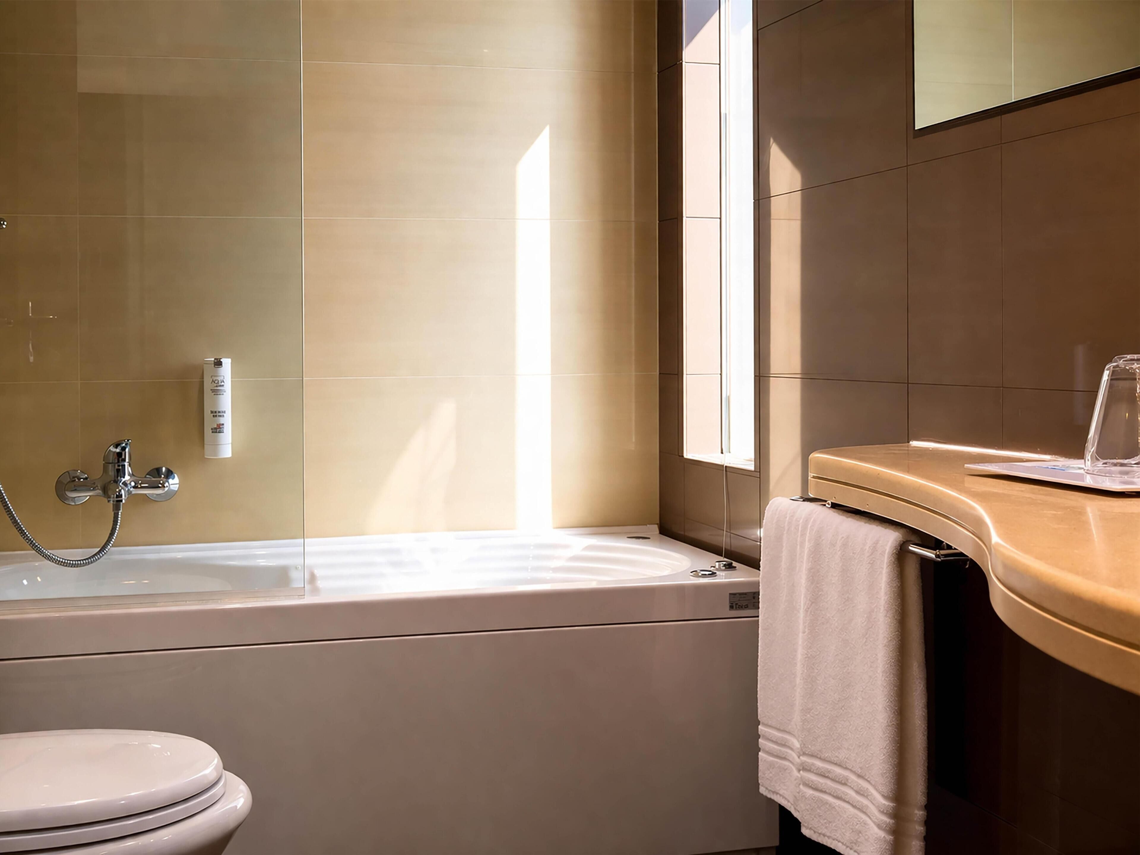 Une salle de bain avec une baignoire, des toilettes et un porte-serviettes.