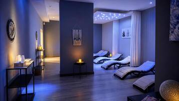 A modern spa room with a massage area, a reception desk, and a wall-mounted light fixture.