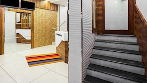 Un hall d’hôtel moderne avec un escalier, un tapis rayé aux couleurs vives et un décor mural en bois.