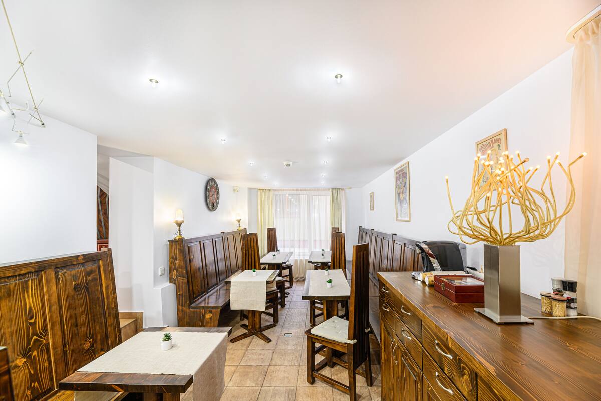 A restaurant with wooden booths, tables, and a bar area.