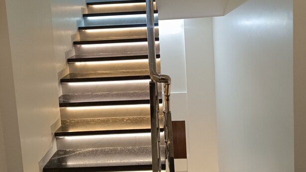 A modern staircase with a metal handrail and illuminated steps. - AR Residency (Mumbai)