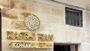 Un muro de piedra con un cartel que dice "KASR-HEAN KONAK".