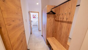 A hallway with wooden wardrobe doors, a bench, and a coat rack. - 070 Phkb9 in St Georgen am Kreischberg (Sankt Georgen am Kreischberg)