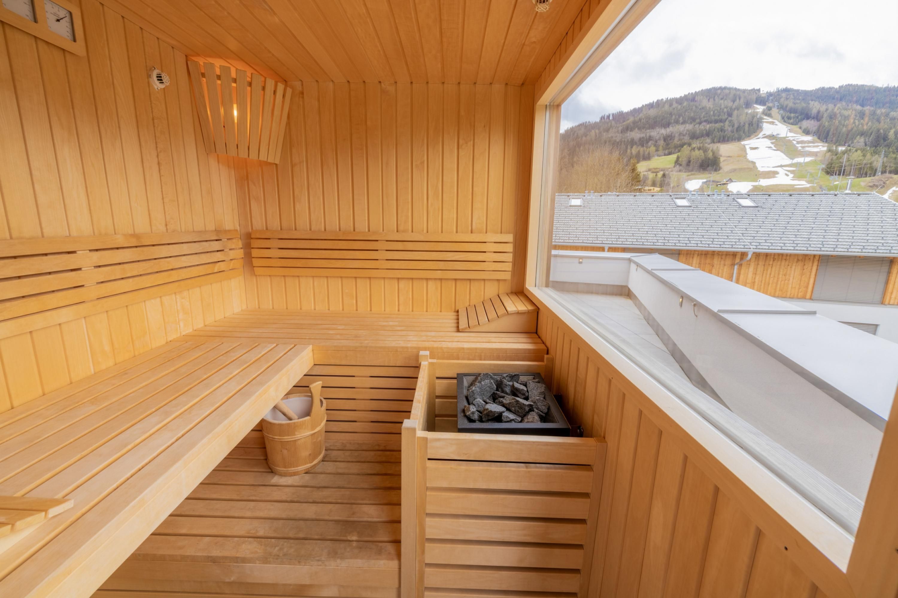 Una sauna in legno con panche e una finestra che si affaccia sul paesaggio.