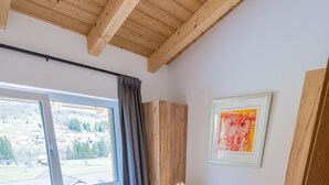 A wooden-framed bed with white linens, a window with curtains, and a framed picture on the wall. - 070 Phkb9 in St Georgen am Kreischberg (Sankt Georgen am Kreischberg)