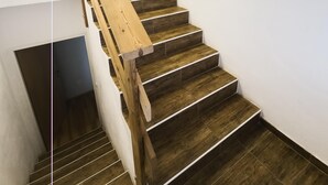 Una scala in legno con ringhiera che porta a un pianerottolo.