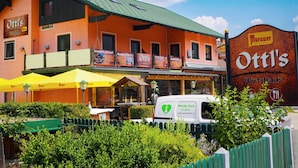 A restaurant named Ottl's with outdoor seating and a sign for Murauer.