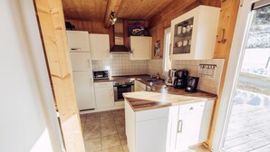 A compact kitchen with white cabinets, a wooden countertop, and a built-in oven. - 022 W2 in St Georgen am Kreischberg (Sankt Georgen am Kreischberg)