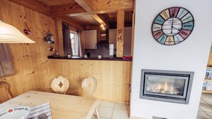 Un interno in legno con angolo cottura, camino e orologio a parete.