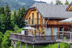 Eine Holzhütte mit Balkon, umgeben von Wald.