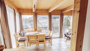A wooden interior with a dining area, a kitchen counter, and a view of the outdoors. - 025 W5 in St Georgen am Kreischberg (Sankt Georgen am Kreischberg)