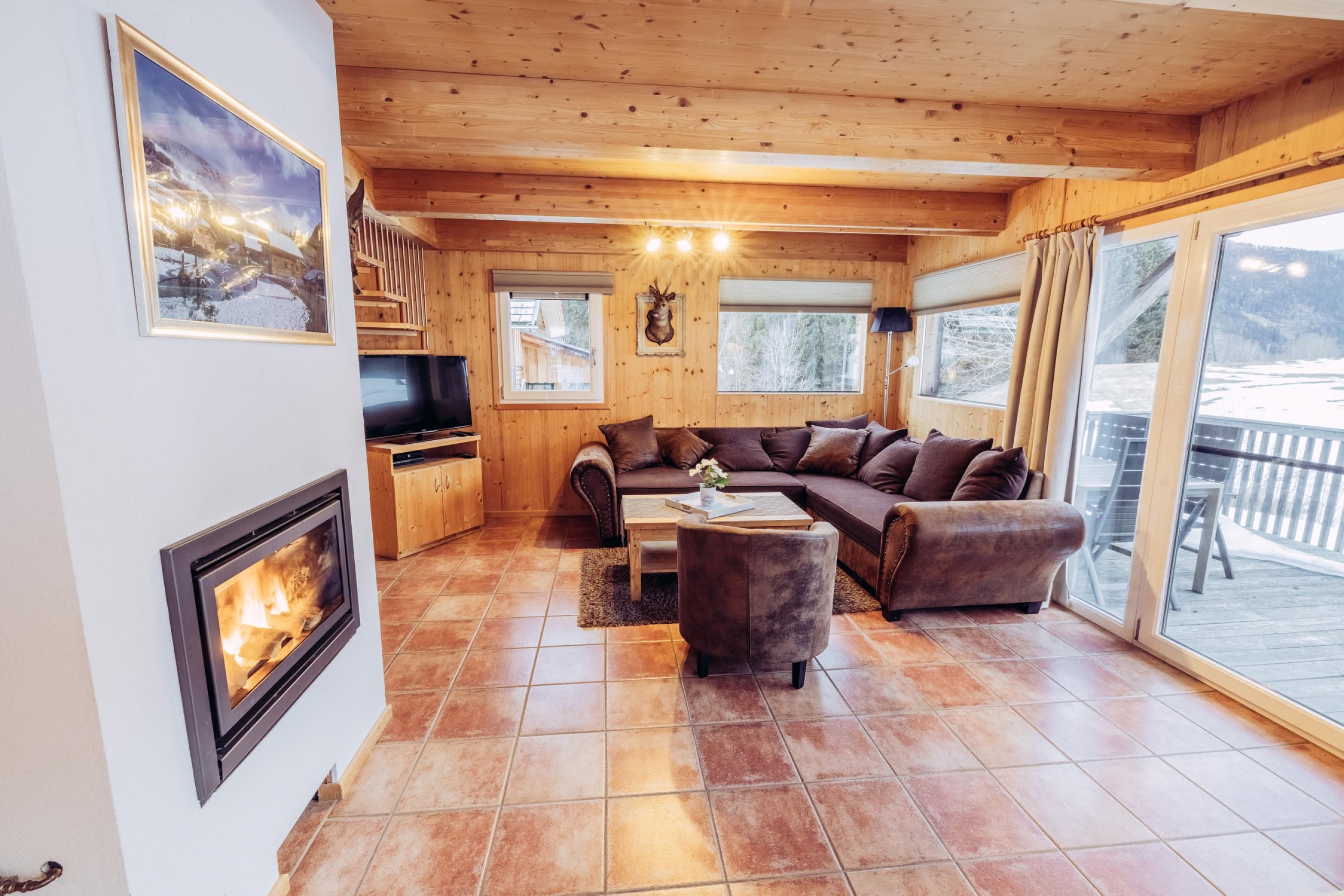 A cozy living room with a fireplace, a sofa set, and a television.