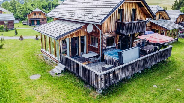 A wooden cabin with a balcony, a hot tub, and a dining area. - 031 W11 in St Georgen am Kreischberg (Sankt Georgen am Kreischberg)