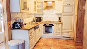 A compact kitchen with wooden cabinets, a microwave, an oven, and a sink. - 031 W11 in St Georgen am Kreischberg (Sankt Georgen am Kreischberg)