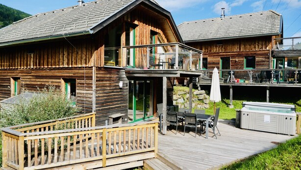 A wooden cabin with a balcony, outdoor seating, and a hot tub. - 034 W14 in St Georgen am Kreischberg (Sankt Georgen am Kreischberg)